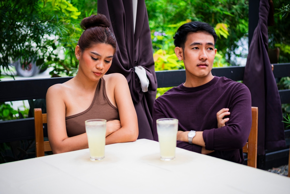 Paar vermeidet beim Date den Blickkontakt und zeigt Desinteresse
