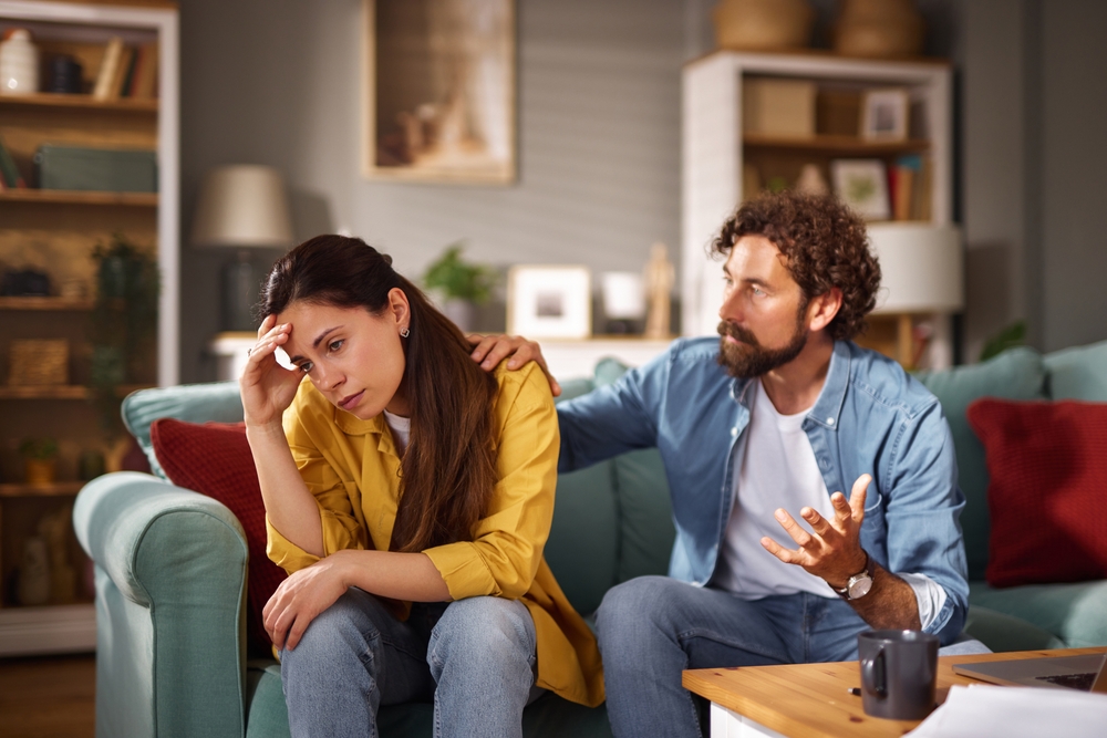 Paar in einem emotionalen Gespraech auf dem Sofa als Symbol fuer Dating, Ueberforderung und gegenseitiges Verstaendnis bei neurodivergenten Menschen.